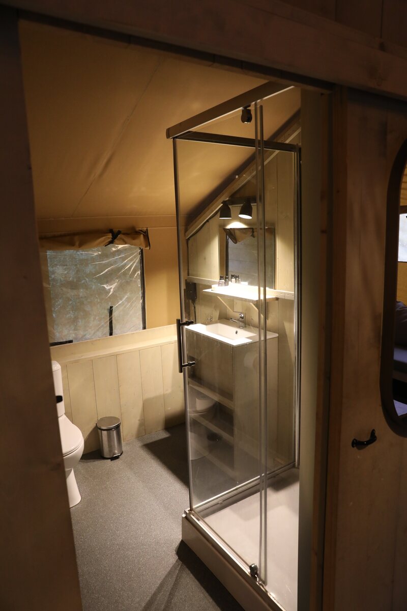 Badkamer met douche in een safaritent op Gooise Heide