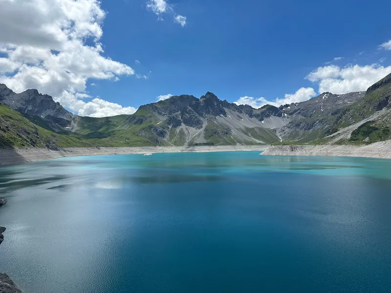 Turquoise bergmeer tussen groene berghellingen