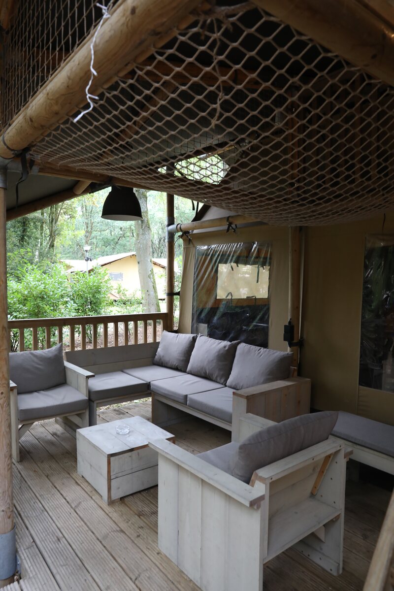 Overdekte veranda met loungeset bij een safaritent op Gooise Heide